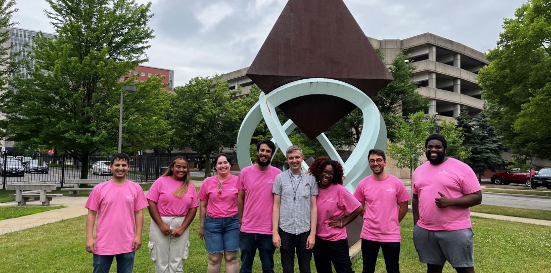 Photo of Moore lab in pink t-shirts on the lawn of the Molecular Biology Research Building